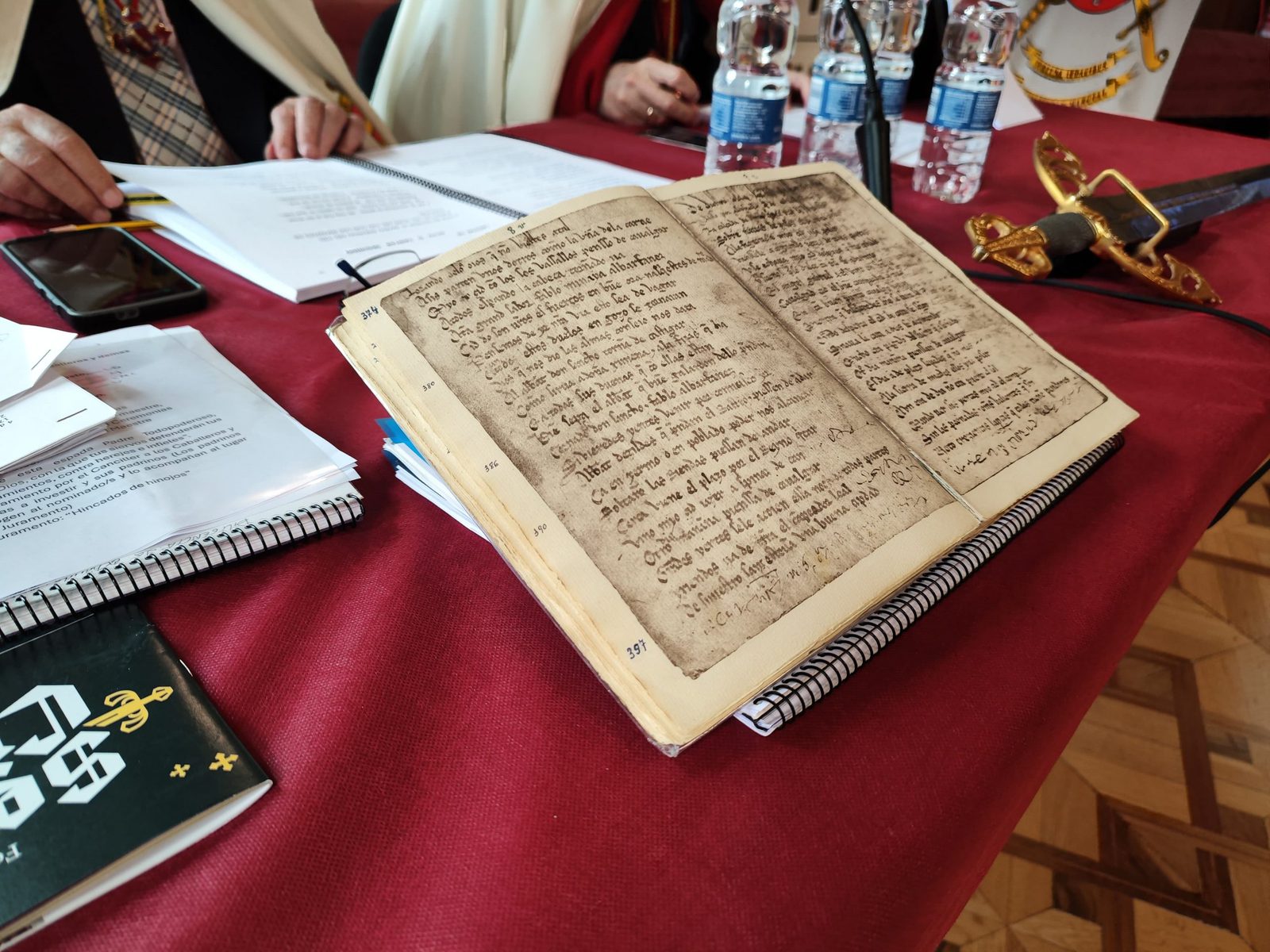 Ejemplar manuscrito del Cantar de Mío Cid abierto sobre la mesa de lectura